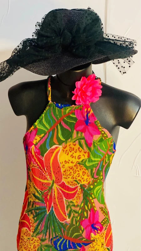 Abito floreale con stampa vivace e cappello nero, perfetto per eventi estivi e giornate al sole.